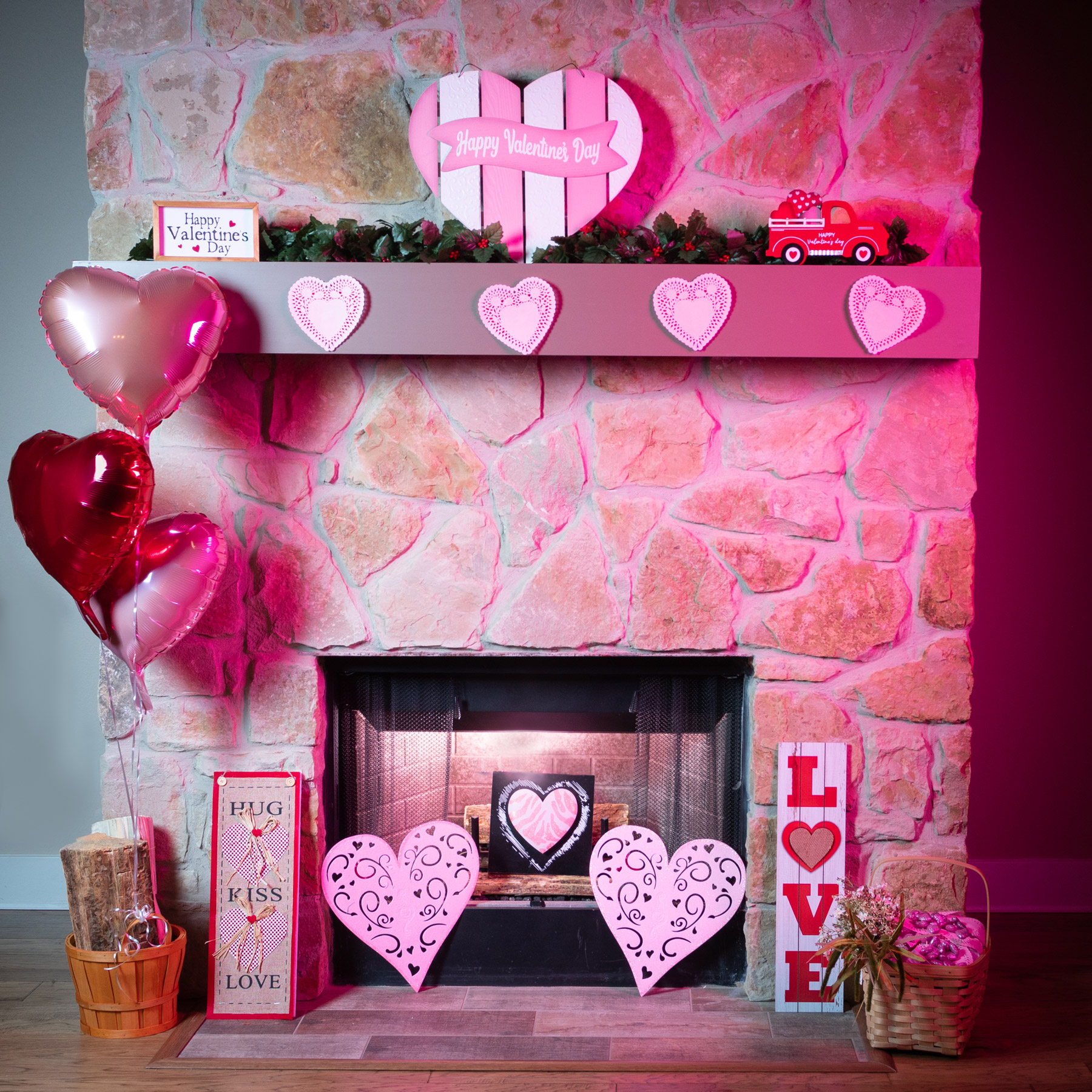 Valentine's Photo setup by the fireplace. It has Pink hearts on the mantle, Pink and red ballons.